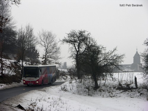Autobus projíždí zasněženou krajinou u obce Hradiště ve Středohoří – ilustrační foto – © PETR BERÁNEK